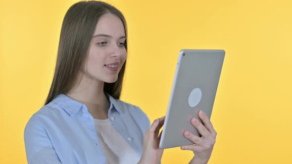 Young Woman Using Tablet, Yellow Background