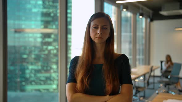 Portrait of Young Successful Redhair Businesswoman Standing in Office Hall Looking at Camera