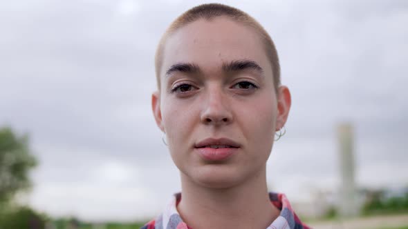 Young bald woman looking at camera outdoor - Authentic people concept