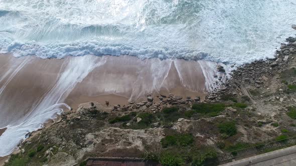 Ocean waves crashing steep coastline cliff. Rocky seashore and waves.