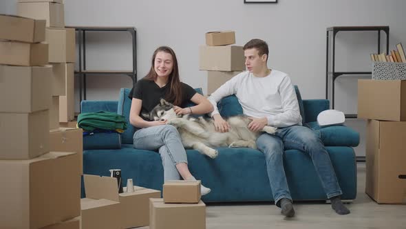 Young Man and Woman are Sitting on the Couch in a New Apartment