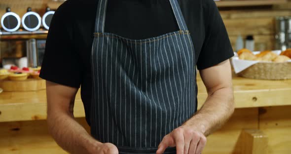 Male waiter using digital tablet in cafe 