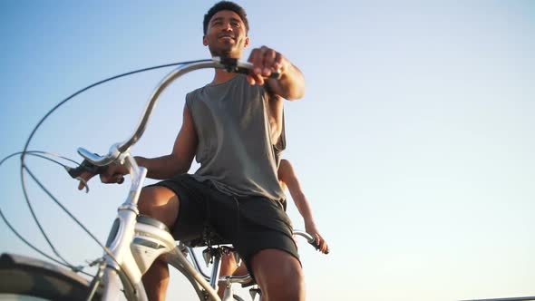 Portrait of a Mixed Race Couple Riding on Tandem Bicycle Outdoors Near the Sea Slow Motion