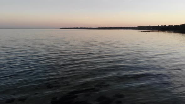 Aerial view flying across the sea in Nykøbing Bugt with swimming and flying seabirds in a beautiful