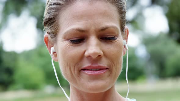 Female athlete listening to music on mobile phone