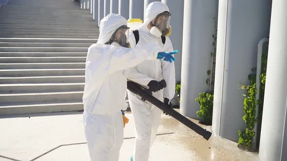 Let's Clean, Disinfect This Places. Two Cleaners in Suits Work Together