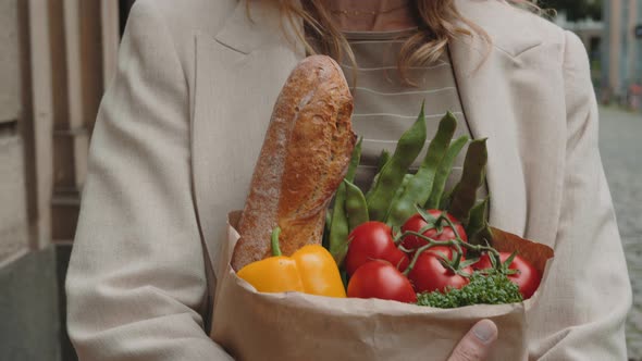 Close Up of Woman Walking on Street with Grocery Bag