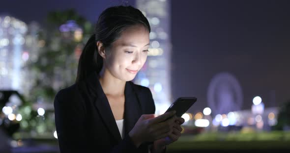 Woman Using cellphone with the background of Hong Kong city 