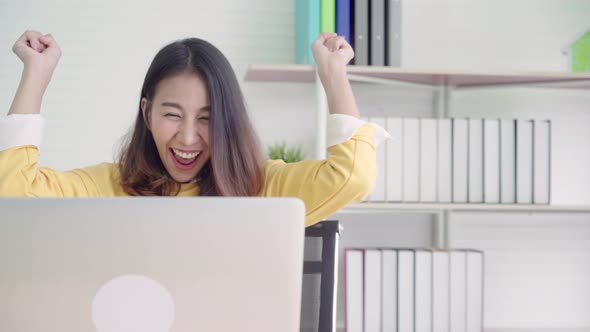 Asia business woman writing notebook document finance and calculator in home office.