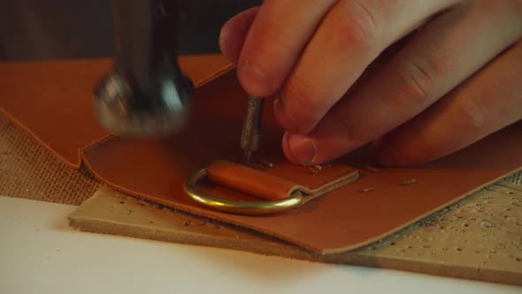 Close-up of the Tailor's Hands Punching Holes for Thread in the Leather Loop of the Bag Handle with