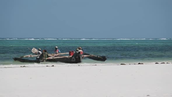 Group of African Fishermen in Traditional Wooden Boat Near the Beach Zanzibar