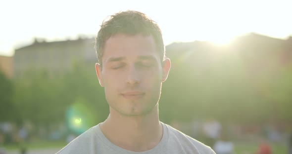 Close Up Portrait of Smiling Caucasian Man in Park Lit By Sunlight