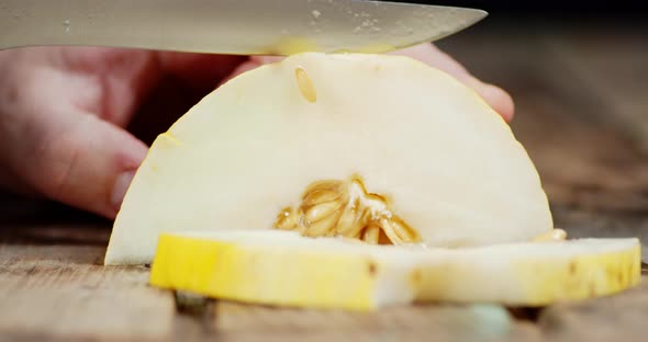 The Hand of a Man Cut Into a Fresh Melon Into Pieces. 