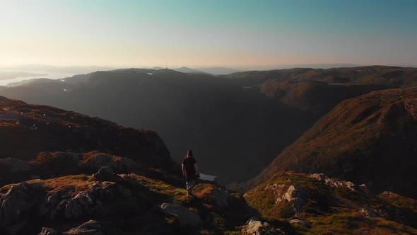 Man walking at the end of a cliff, enjoying the landscape - Aerial 4K