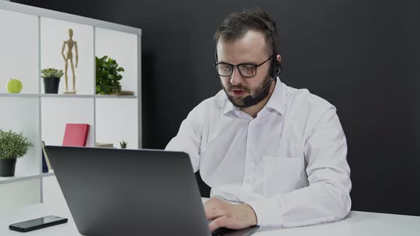 Technical Support Specialist Advises Client. Caucasian Man Wireless Headphones