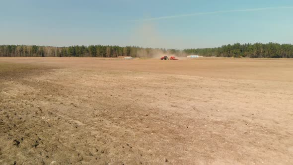 Tractor with a Seeder is Gathering Dust on Spring Farmland