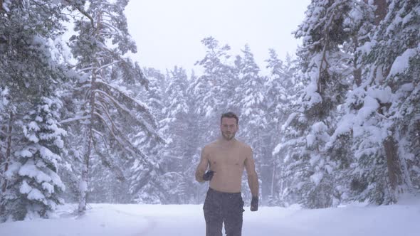 Strong man jogging in the snow.