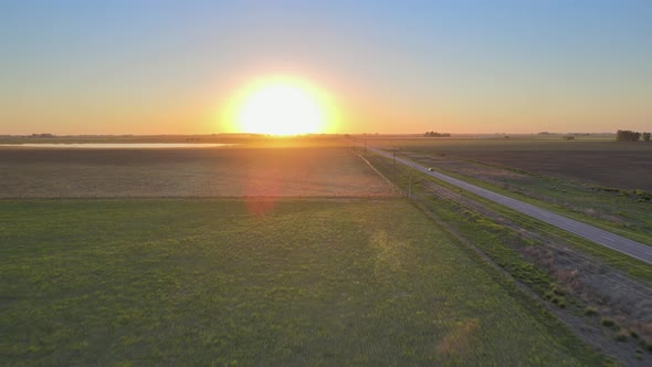 Road running through the Pampas in La Pampa, Argentina, sunset drone