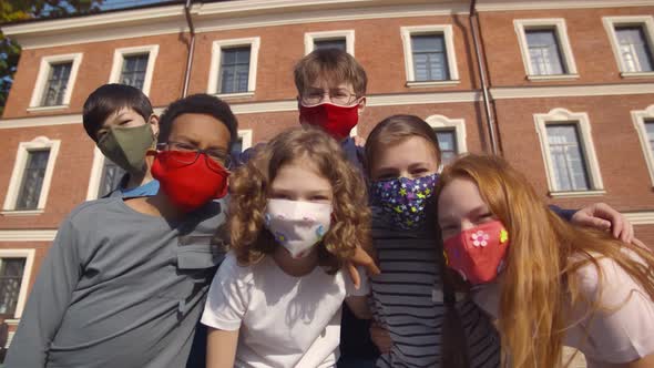 Low Angle View of Diverse School Students Wearing Colorful Protective Mask Looking at Camera