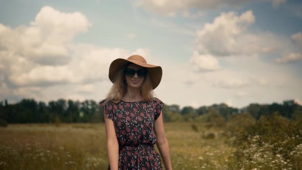 Girl Enjoying In Green Grass Field.Woman Walking In Field.Girl In Wicker Hat Walking On Meadow.