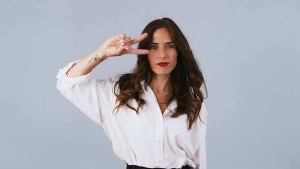 Brunette Female in White Shirt is Looking Happy Smiling and Dancing Funny Dances While Posing