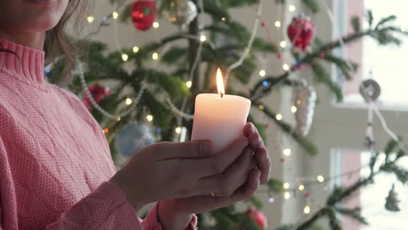 Side View Portrait of Young Woman Indoors at Home at Christmas, Holding Candle.young Woman in a