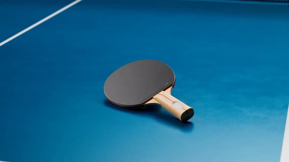 Focus on a table tennis bat. Zooming-out to aerial view on the ping pong table.