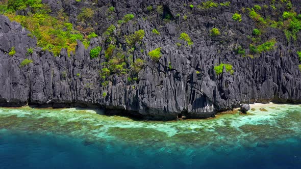 Clear Waters and Jagged Limestone Cliffs of Matinloc Island at Palawan, Philippines