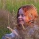 Cute Beautiful Teenager Girl with Long Red Hair Sitting on the Grass on Summer Field Enjoying the - VideoHive Item for Sale