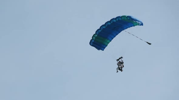 Parachutists in Tandem Flying in the Sky with a Parachute