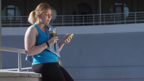 Overweight Woman Jogger Drinking Green Smoothie