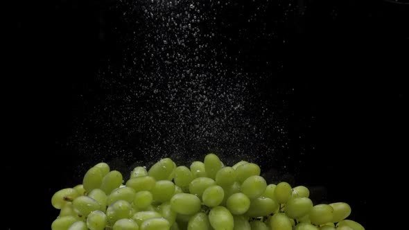 Slow Motion Green Grapes Falling Into Transparent Water on Black Background