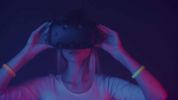 Close Up of Young Girl in Virtual Reality Glasses Putting Hands on Headset, Moves Head and Looks