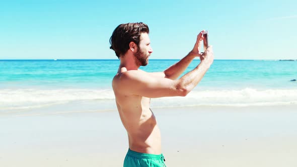 Young man taking a video at beach