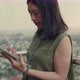 Women use tablets to chat with friends while standing beside a balcony on a rooftop. - VideoHive Item for Sale