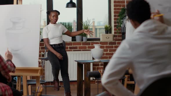 Young Artist Pointing at Vase Model on Table to Teach Drawing Practice