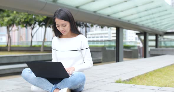 Young Woman using on laptop computer at outdoor