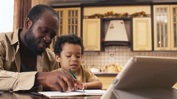 Serious little boy trying to draw hand in hand with his father