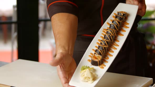 Hands Holding Plate with Sushi