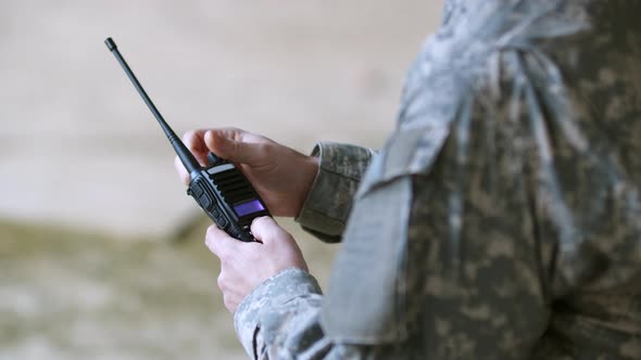 Side View of Soldier in Military Clothing Serviceman Changing Radio Frequency