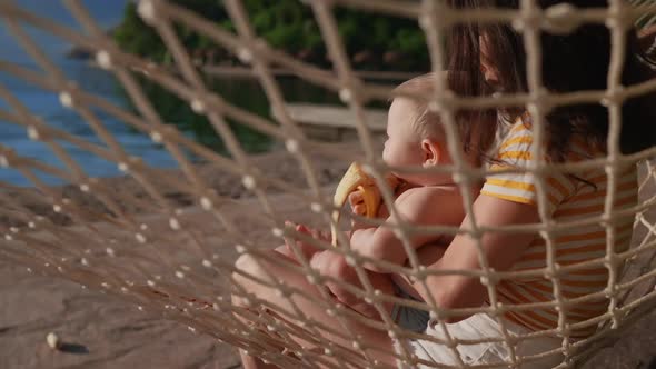 Adult and a Child Swinging and Resting on a Hammock and Move Their Bare Feet