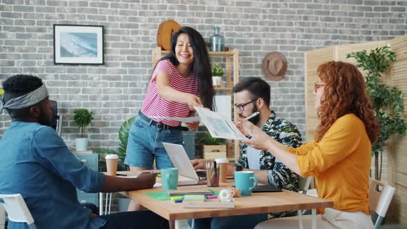 Cheerful Asian Girl Leading Team Meeting About Mobile Phone Interface Design