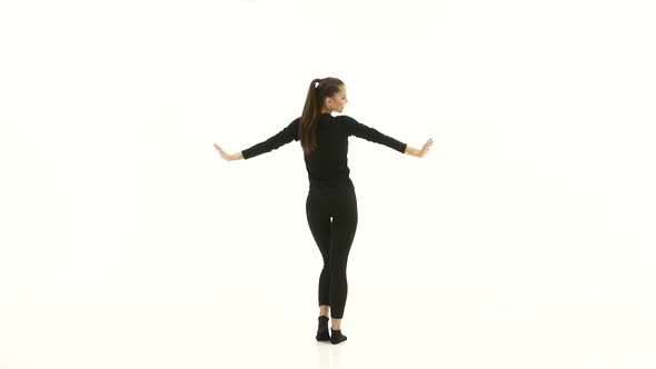 Girl Posing for Video Cameras. White Background. Back View