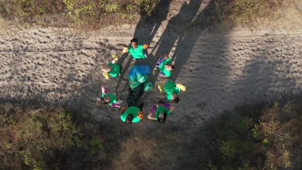 Top View of Activists Posing Around Pile of Trash