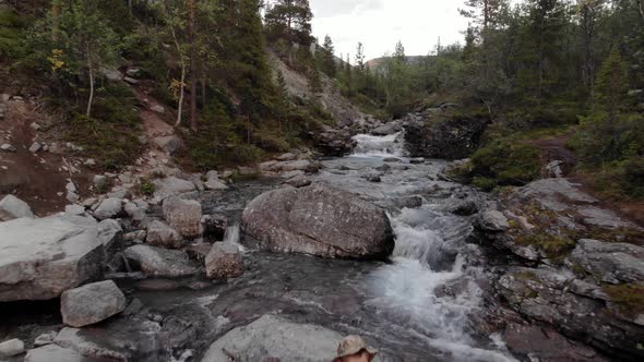 A Close Up of a Man Resting in the Middle of Raging Stream in a Mountain Valley