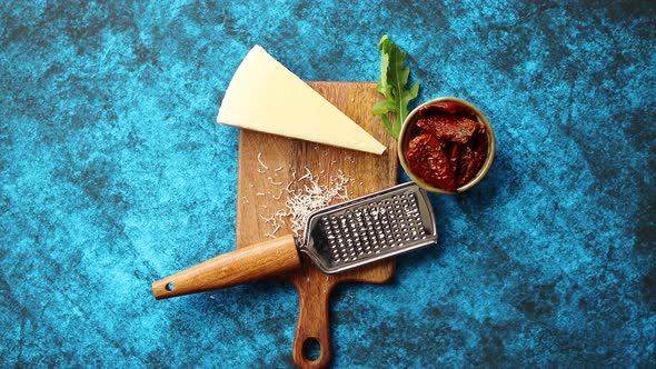 Grated Parmesan Cheese and Metal Classic Grater Placed on Wooden Cutting Board
