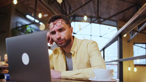 Millennial Male Hold Head with Hand Sitting at Table Falling Asleep Tired Man Fall Asleep Working at