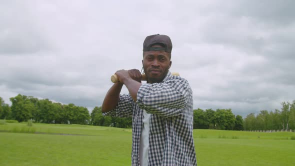 Cool Black Male Baseball Player with Bat Preparing for Batting