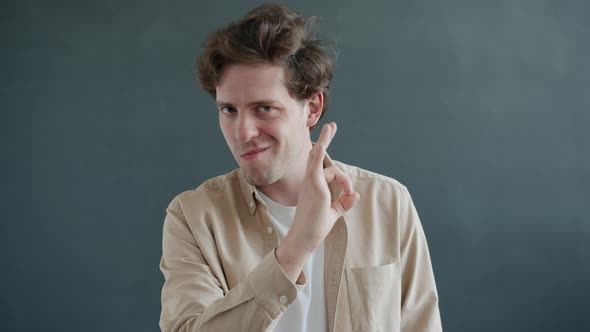 Slow Motion Portrait of Cheerful Guy Showing Ok Hand Gesture and Smiling Looking at Camera