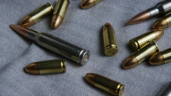 Cinematic rotating shot of bullets on a fabric surface 